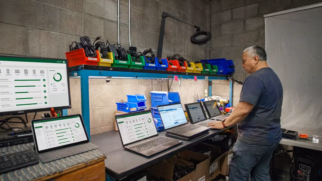 Modern Waste Solutions technician wiping laptops at an ITAD workbench