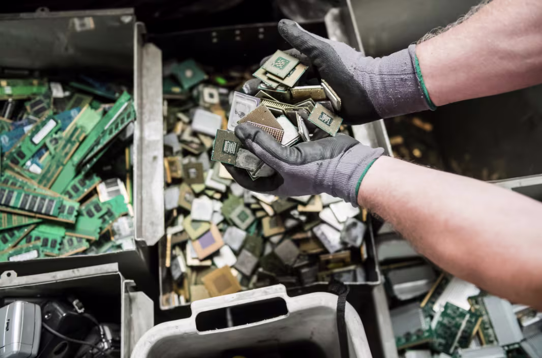 Worker's hands sorting circuit boards for secure recycling