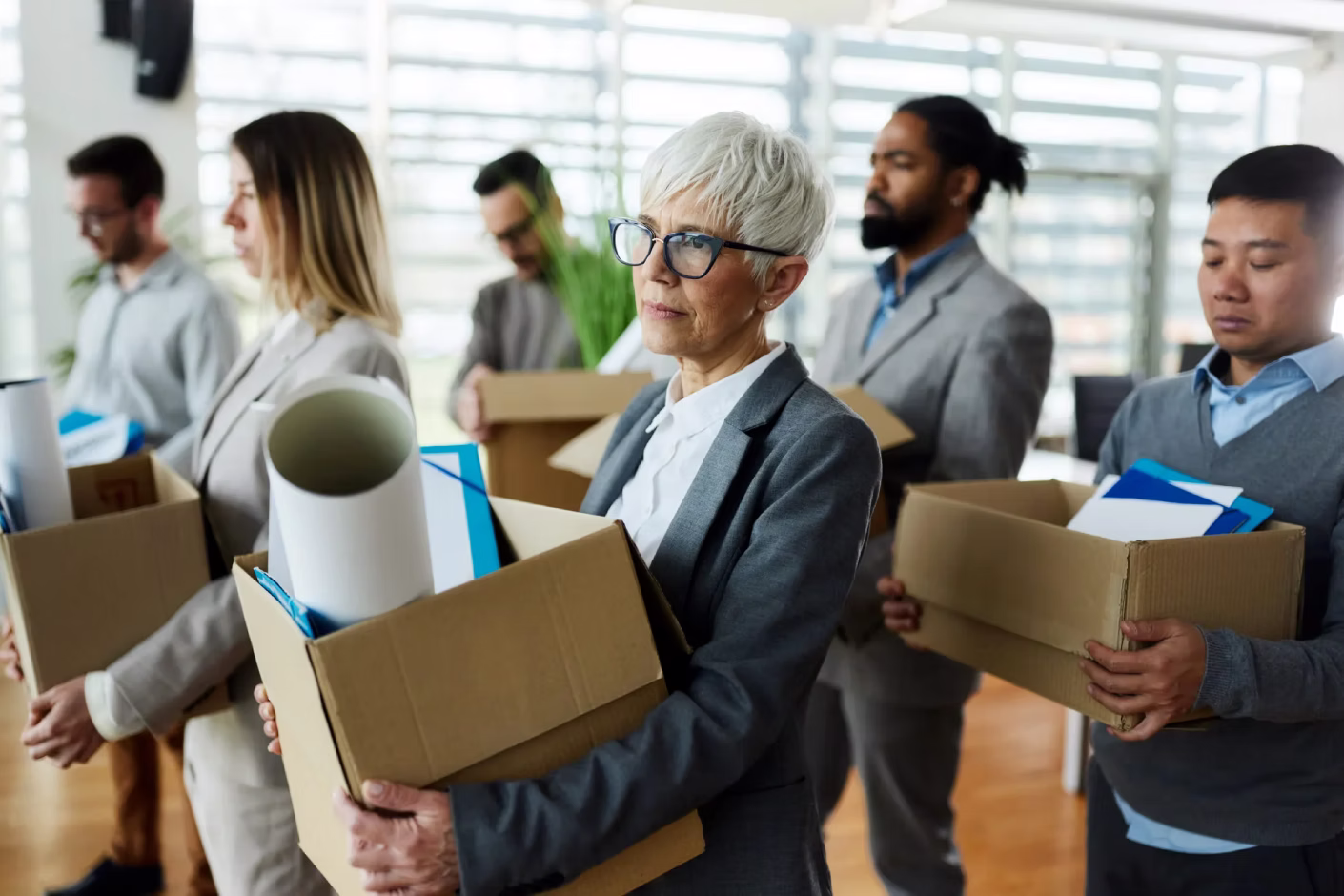 Employees carrying office boxes and equipment indoors during an office clear-out