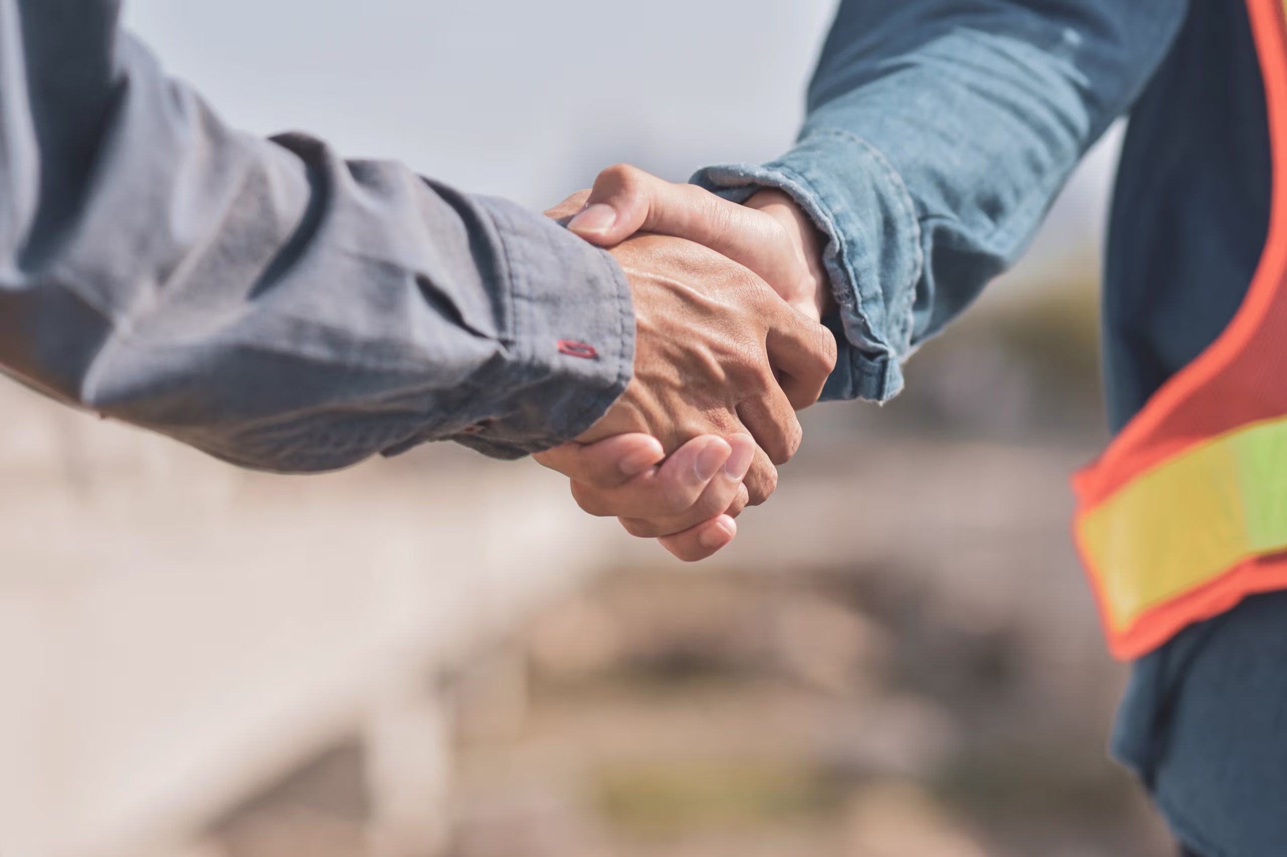 Two people shaking hands outdoors